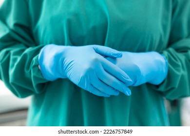 Midsection of female surgeon ready for operation in blue surgical gloves and green gown. Hospital, medical and healthcare services. - Powered by Shutterstock