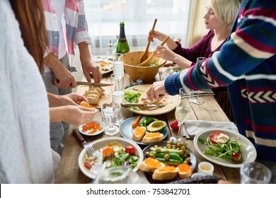 Mid-section Group Of Young People Preparing Dinner For Festive Celebration Standing At Big Table And Making Dishes