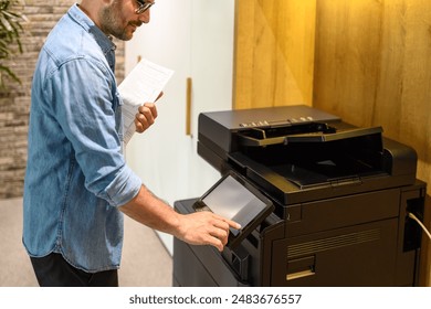 Midsection of male accountant making photocopies of reports through computer printer in modern workplace - Powered by Shutterstock