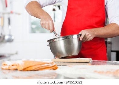 Midsection Of Male Chef Mixing Batter To Prepare Ravioli Pasta In Commercial Kitchen