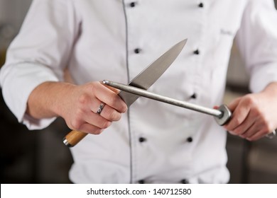 Midsection of male chef sharpening knife in commercial kitchen - Powered by Shutterstock