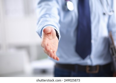 Midsection of male doctor extending his hand for a handshake in clinic