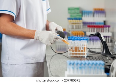 Midsection of male technician scanning barcode on medical sample in laboratory - Powered by Shutterstock