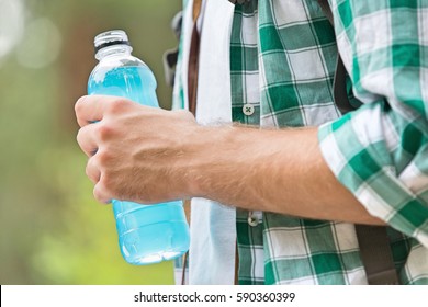 Midsection of man with energy drink outdoors