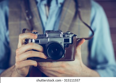 Midsection of man holding camera
