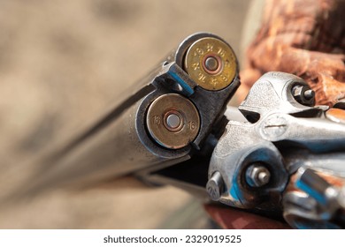 Midsection of man unloading shotgun while standing on field