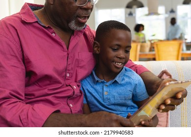 Midsection Of Multiracial Grandfather With Grandson Watching Video Over Digital Tablet At Home. Wireless Technology, Family, Childhood, Unaltered, Lifestyle And Retirement Concept.