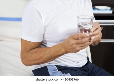 Midsection Of Patient Holding Water Glass In Rehab Center - Powered by Shutterstock