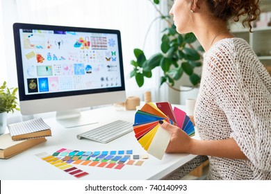 Mid-section portrait of young creative designer working at desk in modern office choosing color palette from swatches - Powered by Shutterstock