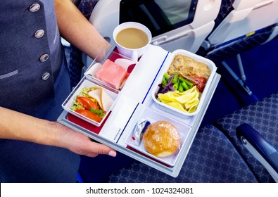 Midsection Of Stewardess Holding Tray With Airplane Food