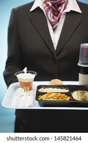 Midsection Of Stewardess Holding Tray With Airplane Food