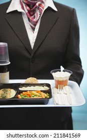 Midsection Of Stewardess Holding Tray With Airplane Food