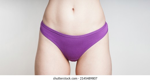 midsection of unrecognizable woman wearing purple cotton panties as women's health or female sexuality concept