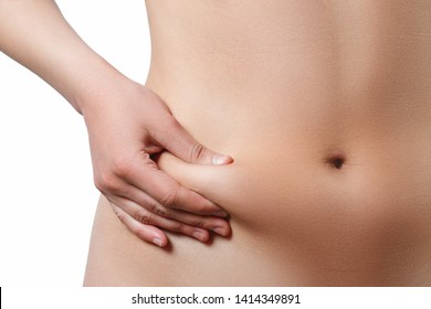 Midsection view of a woman pinching skin for fat test. Isolated on white background.