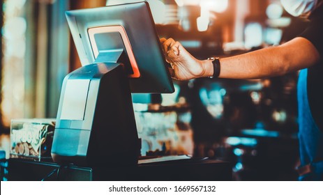 Midsection of waiter touching computer monitor at counter in coffee shop - Powered by Shutterstock