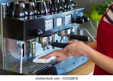 Mid-section of waitress wiping espresso machine with napkin in cafÃ© - Powered by Shutterstock