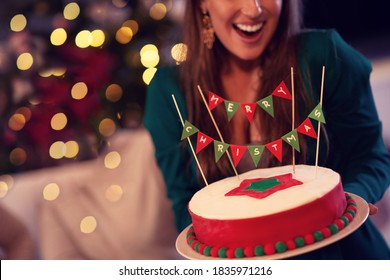 Midsection Of Woman Holding Christmas Cake