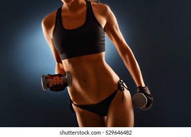 Midsection Of Woman Lifting Dumbells