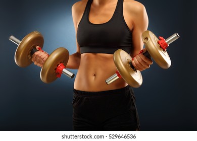 Midsection Of Woman Lifting Dumbells