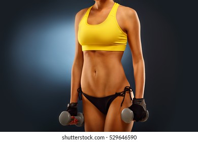 Midsection Of Woman Lifting Dumbells