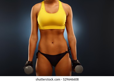 Midsection Of Woman Lifting Dumbells