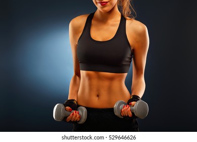 Midsection Of Woman Lifting Dumbells