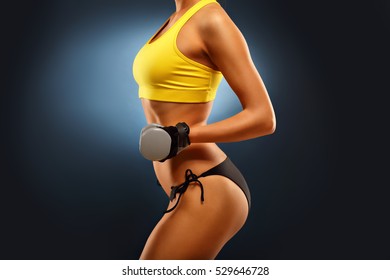 Midsection Of Woman Lifting Dumbells