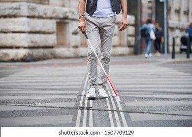 Midsection of young blind man with white cane walking across the street in city. - Shutterstock ID 1507709129