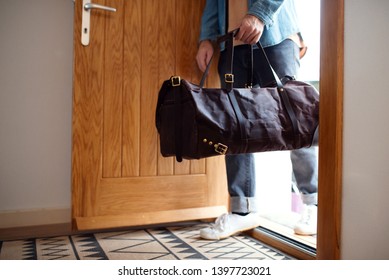 Midsection Of Young Man With Bag Entering Front Door When Coming Back Home.