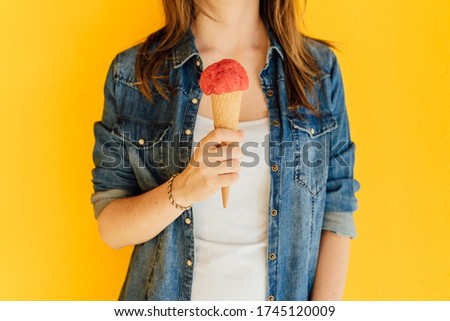 Midsection of young woman holding ice cream cone. Summer