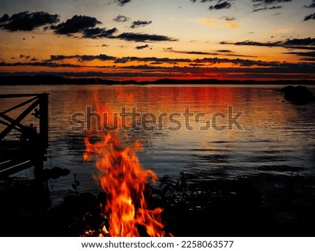 Midsummer fires on a lake side while sunset turning to sunrise. 