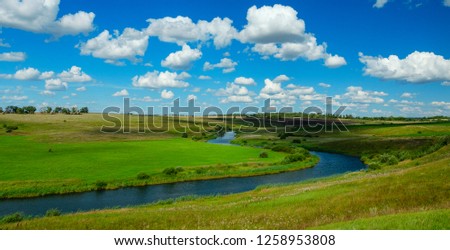 Midsummer.Country landscape.Sunny summer scene with river curve,fields,green hills,distant woods and beautiful clouds in blue sky.Beautiful panoramic view.River Upa in Tula region,Russia. 