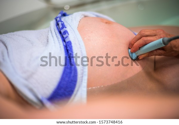 Midwife checks the heart beat of a child. Natural
birth in water.
