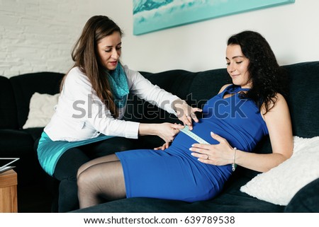 Midwife measuring a belly of a pregnant woman