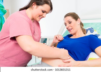 Midwife or nurse and pregnant woman in delivery room of hospital