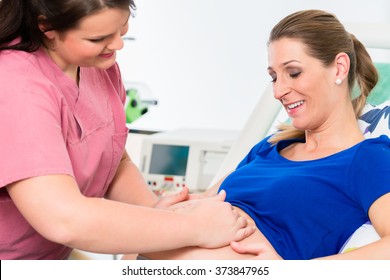 Midwife Or Nurse And Pregnant Woman In Delivery Room