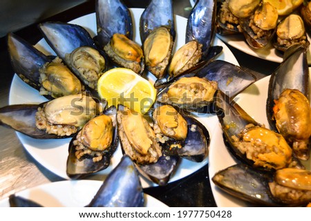 Midye dolma, stuffed mussels Turkish food with a beautiful presentation, in a white plate