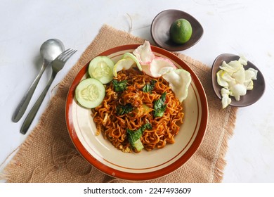 mie tek tek or fried noodle made with egg noodles with chicken, cabbage, mustard greens, meatballs, scrambled eggs. indonesian food