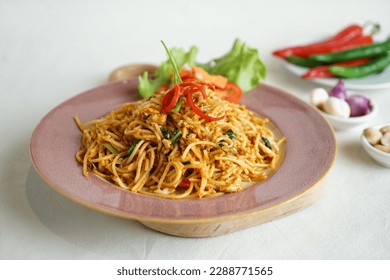 mie tek tek or  javanese fried noodle made with egg noodles with chicken, cabbage, meatballs, scrambled eggs. indonesian food