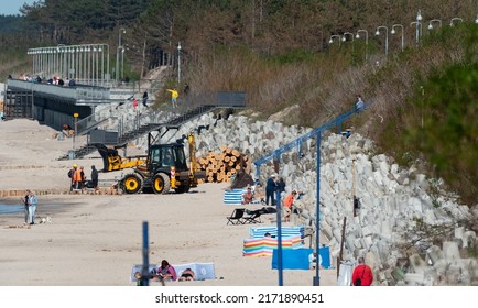 Mielno, Poland - May 23, 2022: Construction Of Breakwaters By The Beach In Mielno. Wide Beach With Construction Machinery. Repair Of Breakwaters.