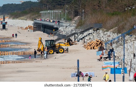 Mielno, Poland - May 23, 2022: Construction Of Breakwaters By The Beach In Mielno. Wide Beach With Construction Machinery. Repair Of Breakwaters.