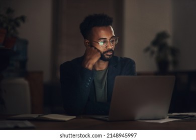 It Might Be Time To Re-evaluate Why You Work Here. Shot Of A Young Businessman Looking Worn Out While Using A Laptop During A Late Night At Work.