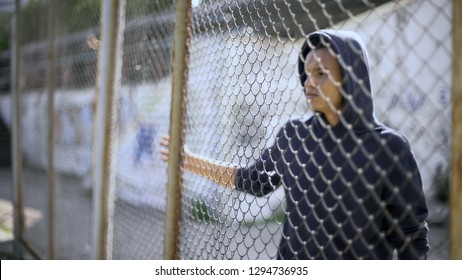 Migrant child separated from family, afro-american boy behind fence, detained - Shutterstock ID 1294736935