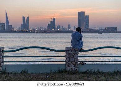 A Migrant Worker Makes A Phone Call While Watching The Sun Set Over Manama, Bahrain.  October 1, 2017.