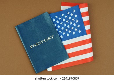 Migration Concept. On A Brown Surface Lies A Passport With The US Flag Inside.