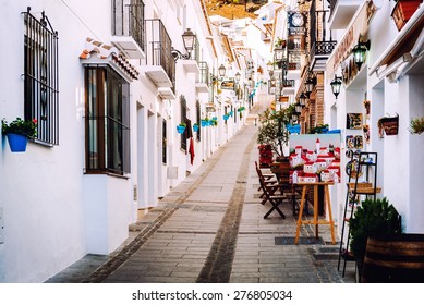 Mijas, Spain- January 05, 2014: Charming whitewashed narrow street In Mijas lined with cafes, restaurants and souvenir shops. Mijas is a lovely Andalusian white village on the Costa del Sol. Spain