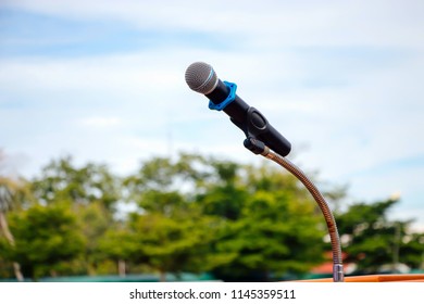 Mike Is Located On A Podium On An Outdoor Stage.