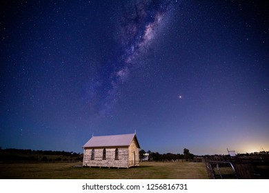 Mikly way universe starry sky over rustic old timber chapel and  rural field in Australia