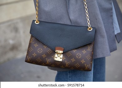 MILAN - FEBRUARY 24: Woman with Louis Vuitton bag before Tod's fashion show, Milan Fashion Week street style on February 24, 2017 in Milan.