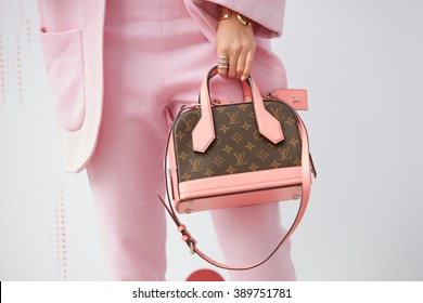 MILAN - FEBRUARY 25: Woman poses with pink and brown Louis Vuitton bag and pink suit before Costume National fashion show, Milan Fashion Week Day 2 street style on February 25, 2016 in Milan.